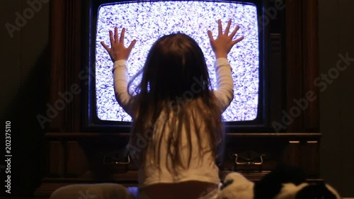 Little girl stares at eerie TV screen as in a iconic movie