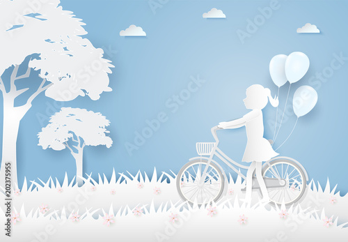 Fototapeta Dziewczyna z rowerem i balonami w polu kwiatów kosmosu na niebieskim niebie papierowa sztuka, tło w stylu cięcia papieru
