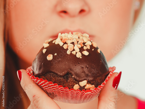 Cute blonde woman about to eat cupcake