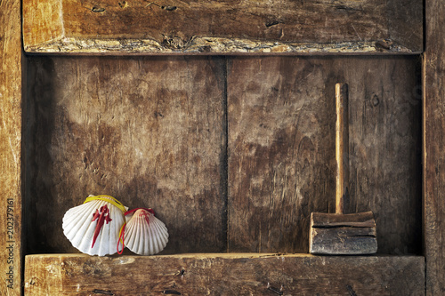 Fotografia Compostela pilgrim scallops in wooden background