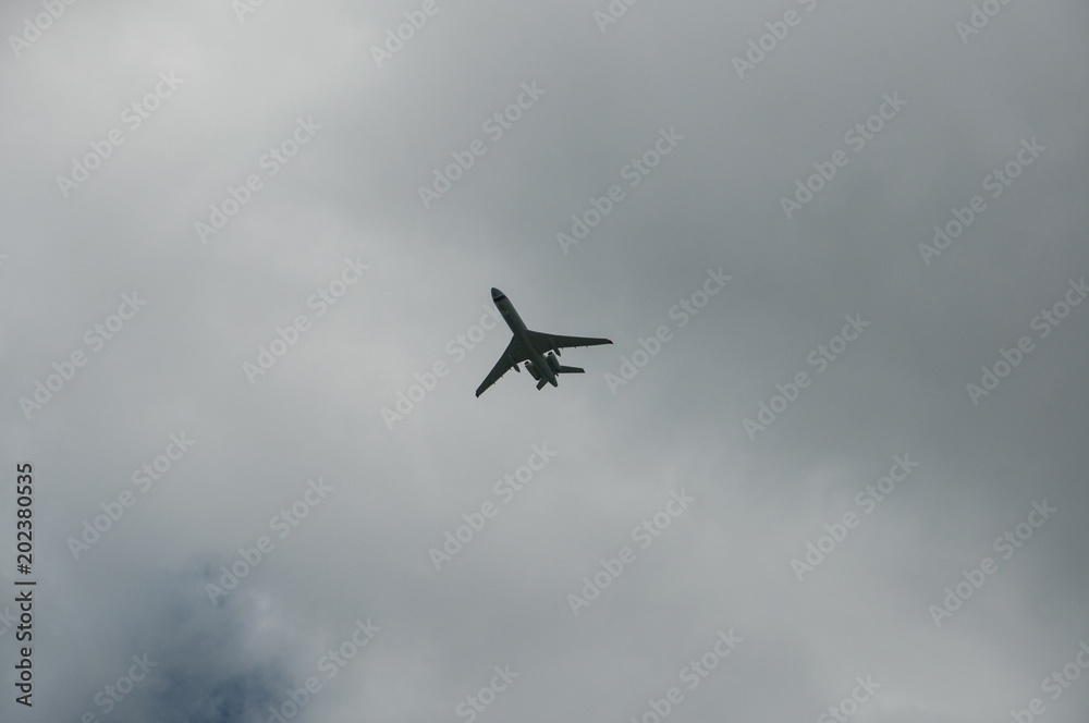 a passenger plane flies against the backdrop of a stormy sky a passenger plane flies against the backdrop of a stormy sky