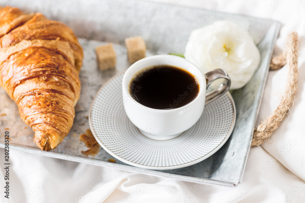 Fresh Croissant, Cup of Coffee and Ranunculus Flowers. Breakfast Fresh Croissant, Cup of Coffee and Ranunculus Flowers. Breakfast