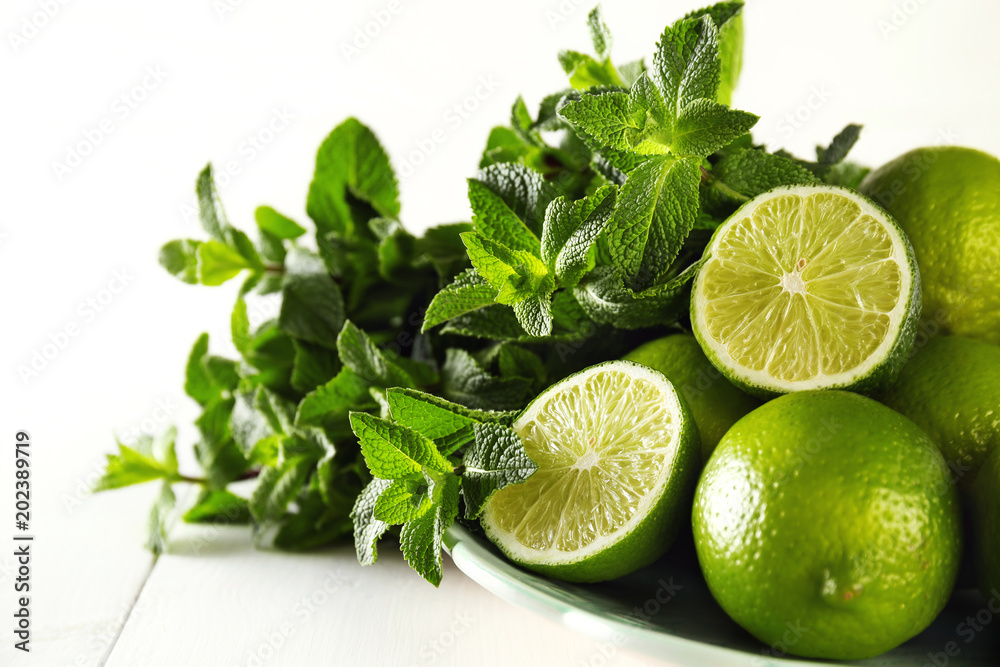 Green fruit, lime and mint on a white background. Ingredients for cooking mojito. Close-up. Green fruit, lime and mint on a white background. Ingredients for cooking mojito. Close-up.