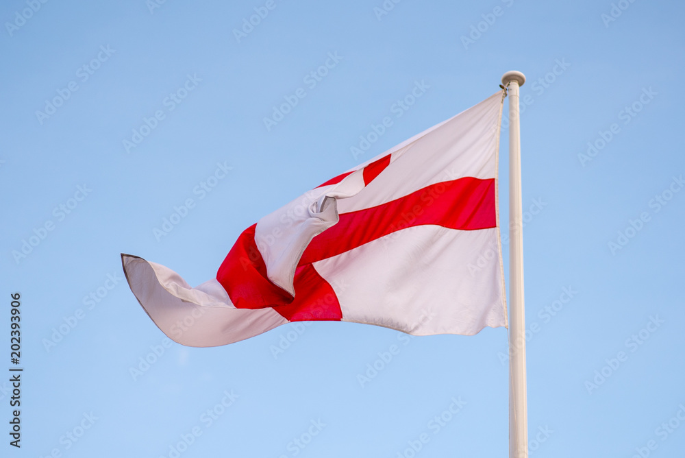 Φωτογραφία national flag of England St Georges flag blowing in the wind with blue sky in ba
