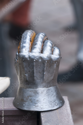 Medieval armor, detail of an ancient armor. Steel gloves on wooden background. photo