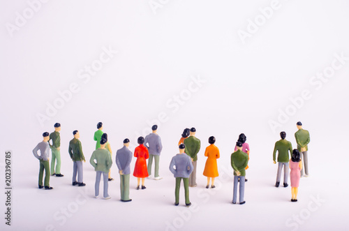 A crowd of people is standing and looking at the white background. People are looking at the white screen. Place for text. The society is watching the event. Observation of the object. Selective focus