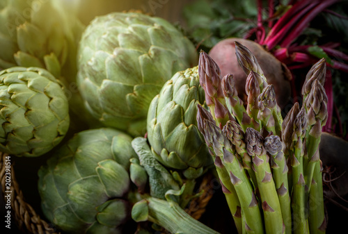 A still life of artichokes and asparagus on the rustic textured background Morning light 2