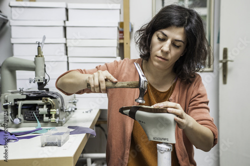 Woman designer making handmade shoes in her workshop