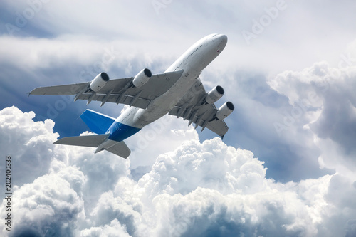  Big four engine plane on the sky with clouds. Aircraft on long intercontinental flights.