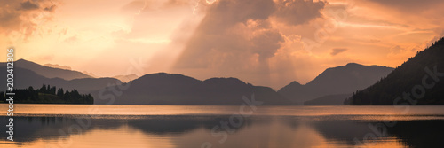 Sonnenaufgang am See in den Bergen unter Gewitter - Panorama