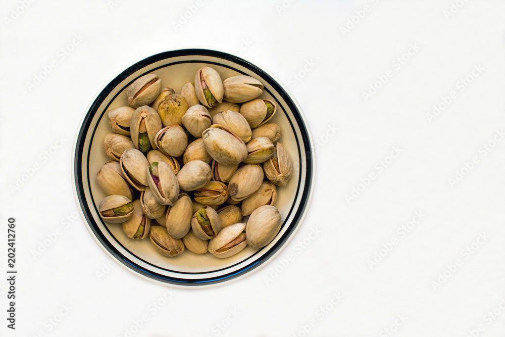 Bowl of Pistachio Nuts on a White Background Bowl of Pistachio Nuts on a White Background
