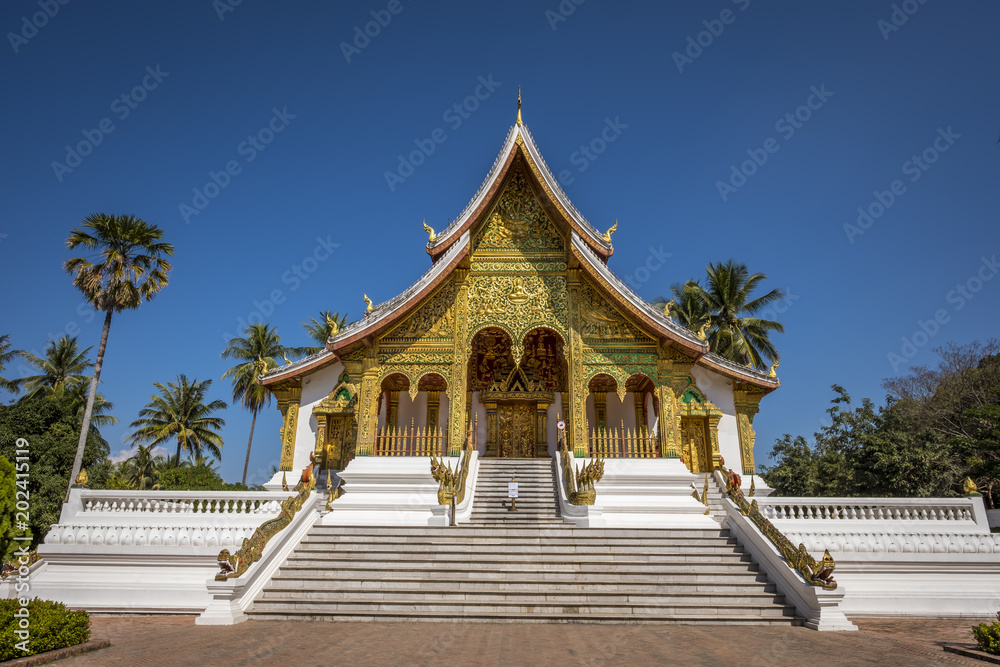 View of the temple in a blur background of surrounding trees in the courtyard of the Grand Palace of Luang Prabang in Laos View of the temple in a blur background of surrounding trees in the courtyard of the Grand Palace of Luang Prabang in Laos