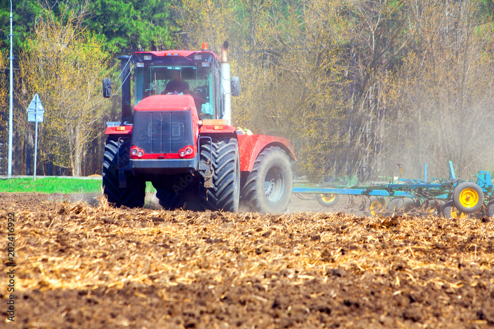 Farmer in tractor preparing land with seedbed cultivator Farmer in tractor preparing land with seedbed cultivator