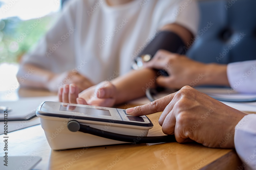 Fototapeta premium Patient listening intently to a male doctor explaining patient symptoms or asking a question as they discuss paperwork together in a consultation