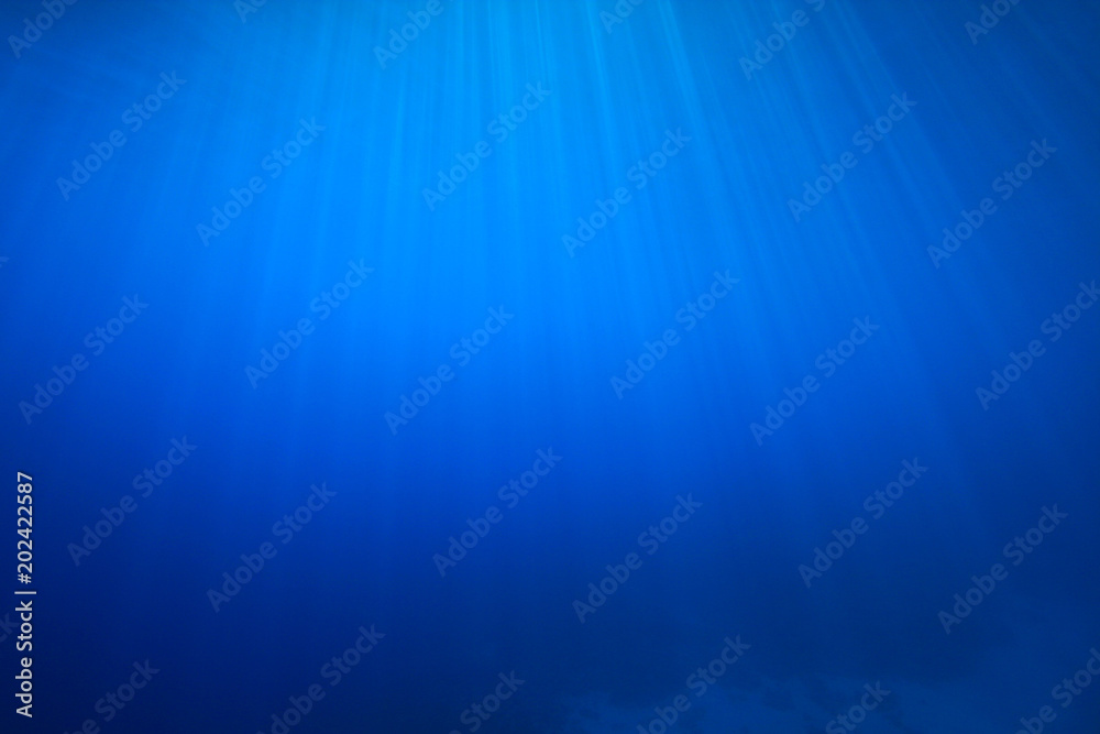 Underwater background. Blue ocean and sunbeams  