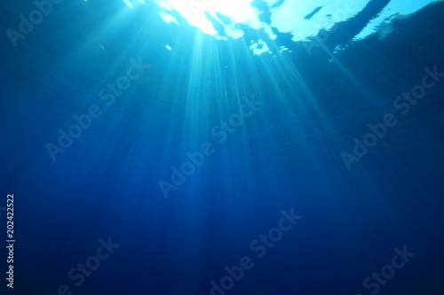 Underwater background. Blue ocean and sunbeams 