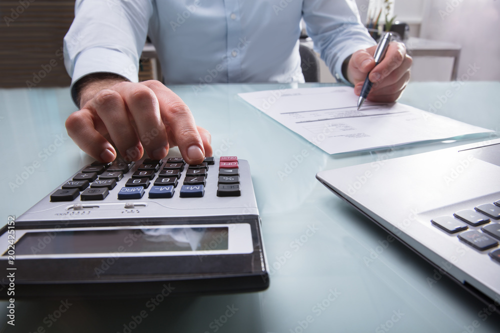 Businessperson Calculating Invoice Businessperson Calculating Invoice