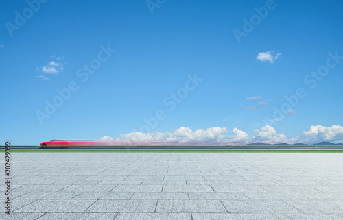 Red sport car moving fast with clear sky and marble floor background .