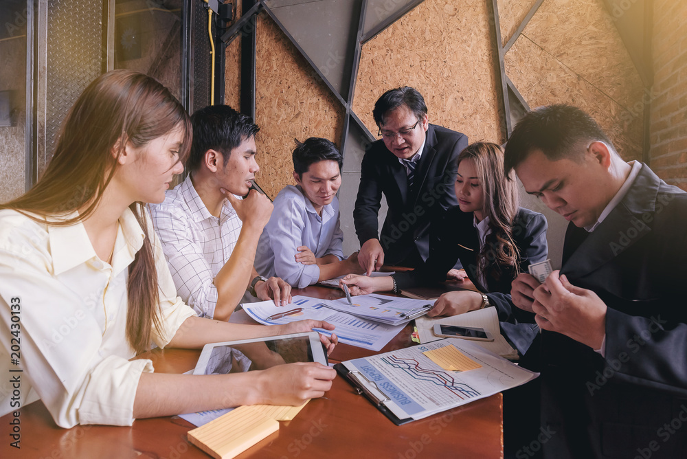 Foto Business people meet to discuss the situation of marketing in the office and have information sheets on the table