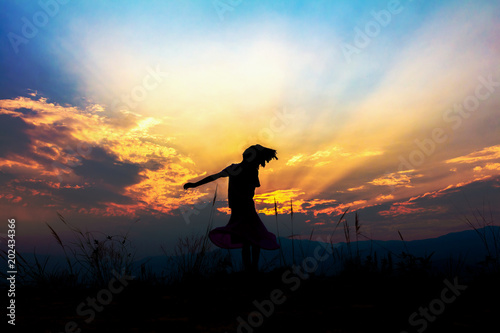 Silhouette small girl playing sunset background