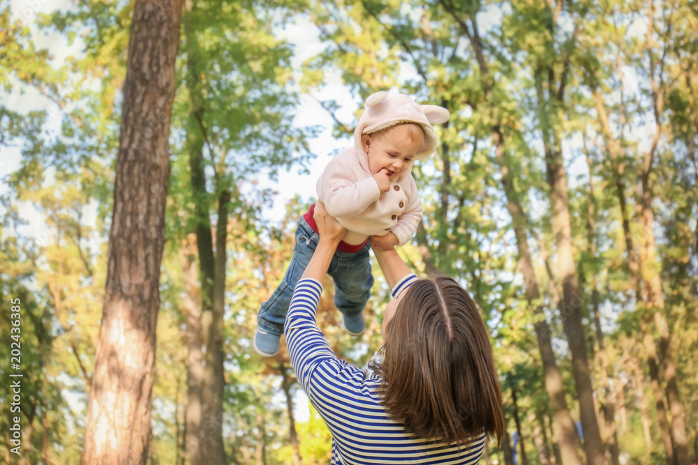 Mother with adorable little girl playing together in autumn park Mother with adorable little girl playing together in autumn park