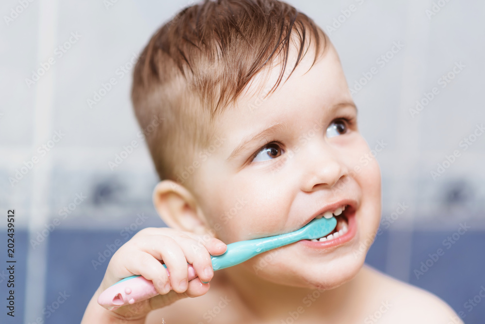 lovely baby brushing his teeth with a toothbrush in the bathroom lovely baby brushing his teeth with a toothbrush in the bathroom