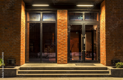 Two glass doors in a brick building in the night