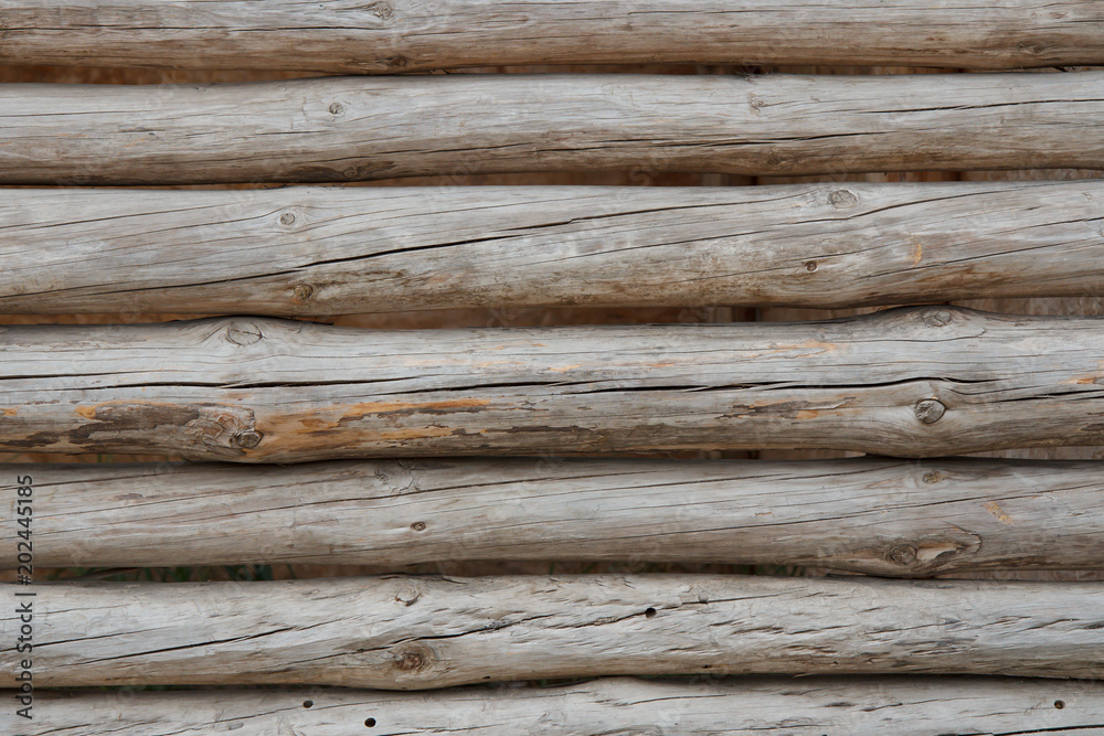 Wooden fence. Background with horizontal old wooden logs Wooden fence. Background with horizontal old wooden logs