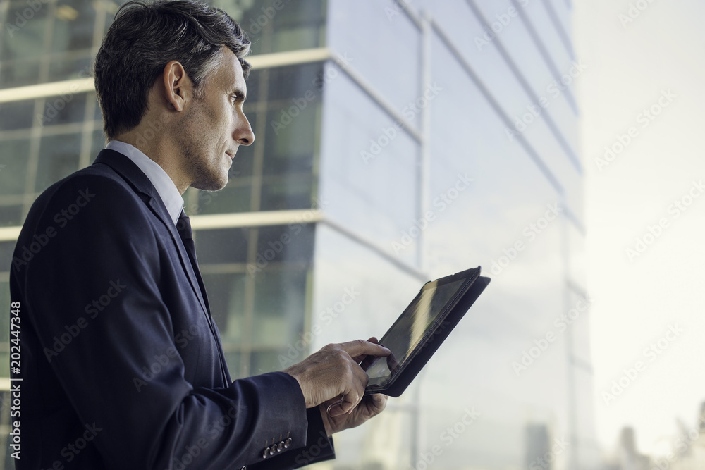 Man with digital tablet by window in high rise building Man with digital tablet by window in high rise building