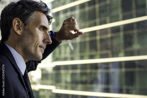 Man looking through window in high rise building