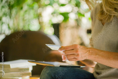 Woman using digital tablet and credit card, cropped