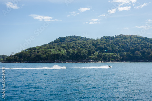 both jet ski riding past Phuket island coast