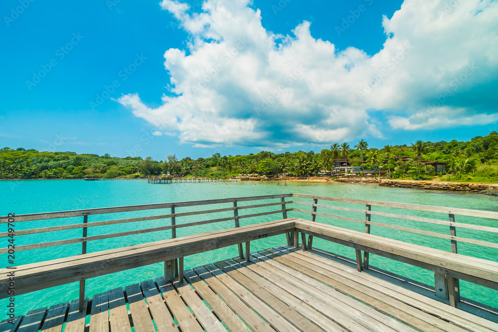 Wooden pier or bridge with tropical beach and sea in paradise island