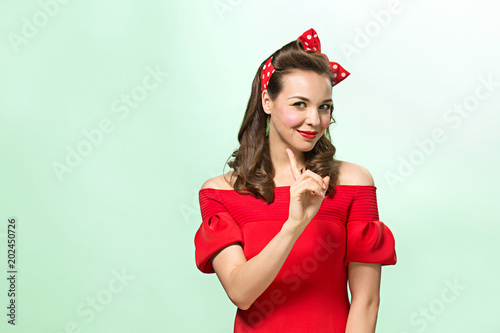 Beautiful young woman with pinup make-up and hairstyle. Studio shot on white background