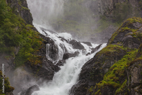 Stunning waterfall on the mountain river in Husedalen valley in Hardangervidda national park, Norway