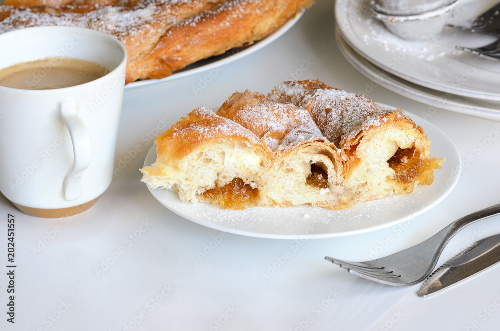.Ensaimada with Cabell d' and cup of coffee. This is traditional pastry in Mallorca, Balearic, Islands and one of the most iconic pastries in Spain eating at breakfast, snack time and dessert.. .Ensaimada with Cabell d' and cup of coffee. This is traditional pastry in Mallorca, Balearic, Islands and one of the most iconic pastries in Spain eating at breakfast, snack time and dessert..