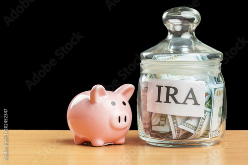 glass jar used for saving US dollar bills and notes for IRA retirement fund