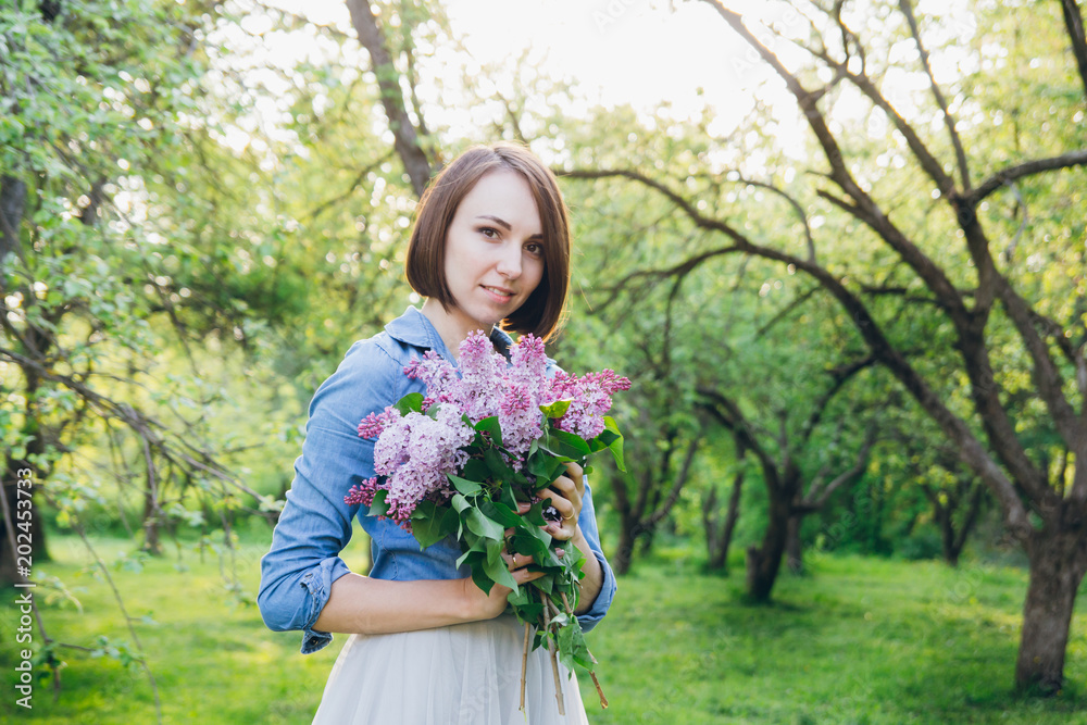 Girl posing with a bouquet of lilac Girl posing with a bouquet of lilac