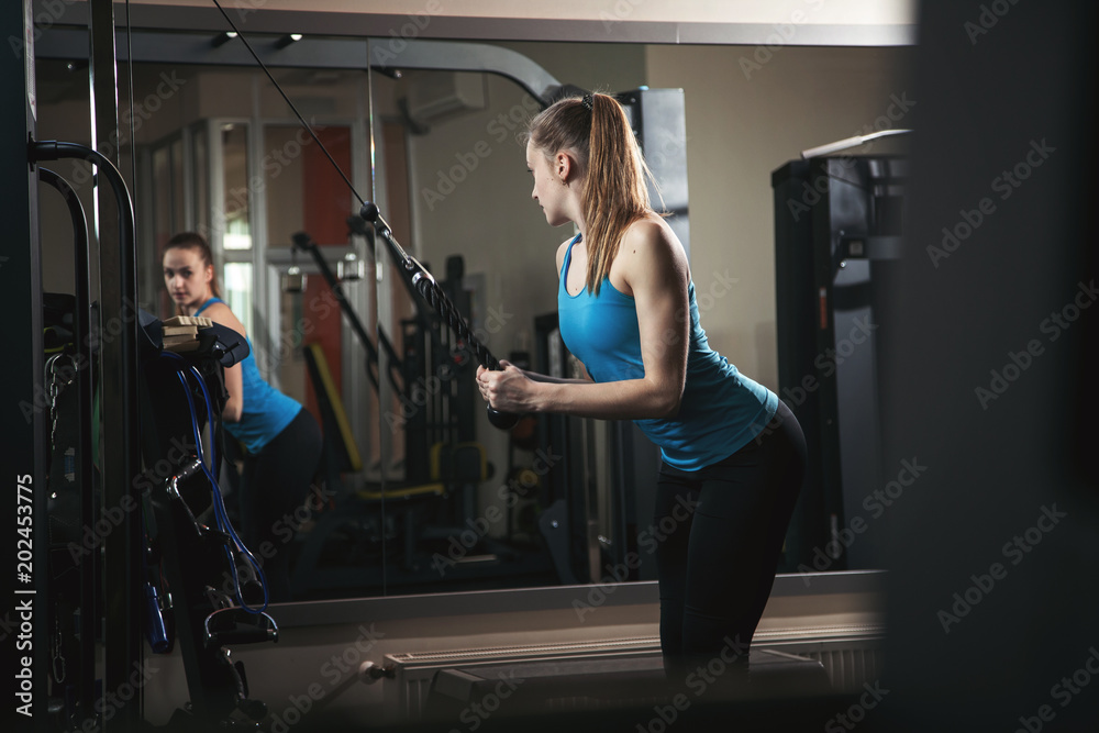  Beautiful girl is exercising in the gym.