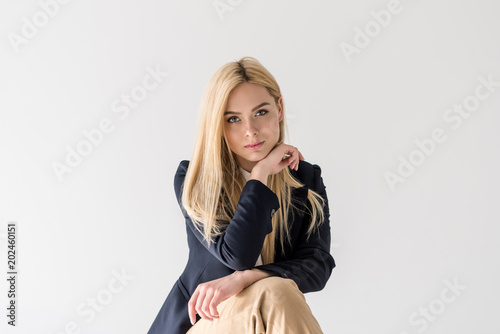 portrait of beautiful stylish blonde girl looking at camera isolated on grey
