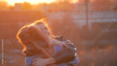 two happy young women, sisters or girlfriends hugging in the background of the sunset. summer vacation, holidays, leisure, travel and people concept photo