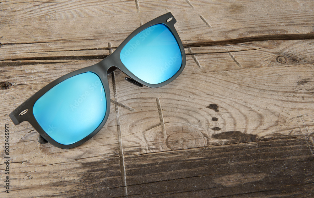 Φωτογραφία blue sunglasses on a wooden background