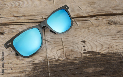 blue sunglasses on a wooden background