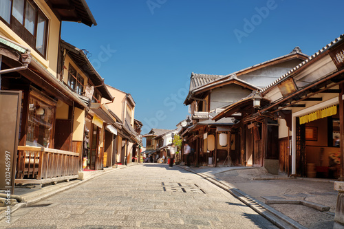 Fototapeta Naklejka Na Ścianę i Meble -  View to small street with Sakura tree in Higashiyama district, Kyoto, Japan. Traditional japanese houses in the morning