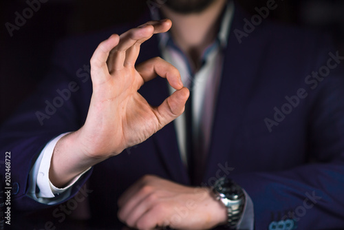 Businessman showing OK by his hand. Reliable business or service concept