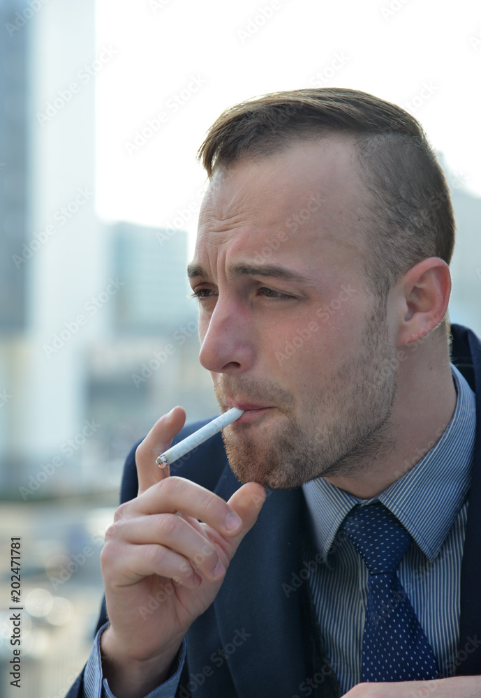 handsome businessman smoking a cigarette handsome businessman smoking a cigarette