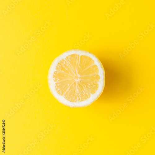 Lemon on vivid yellow background. Minimal summer concept. Flat lay.