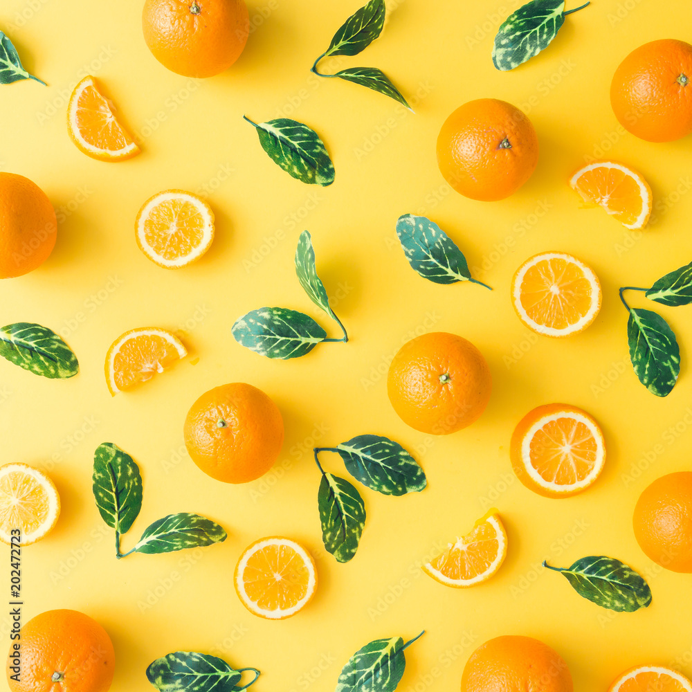 Creative summer pattern made of oranges and green leaves on pastel yellow background. Fruit minimal concept. Flat lay. Creative summer pattern made of oranges and green leaves on pastel yellow background. Fruit minimal concept. Flat lay.