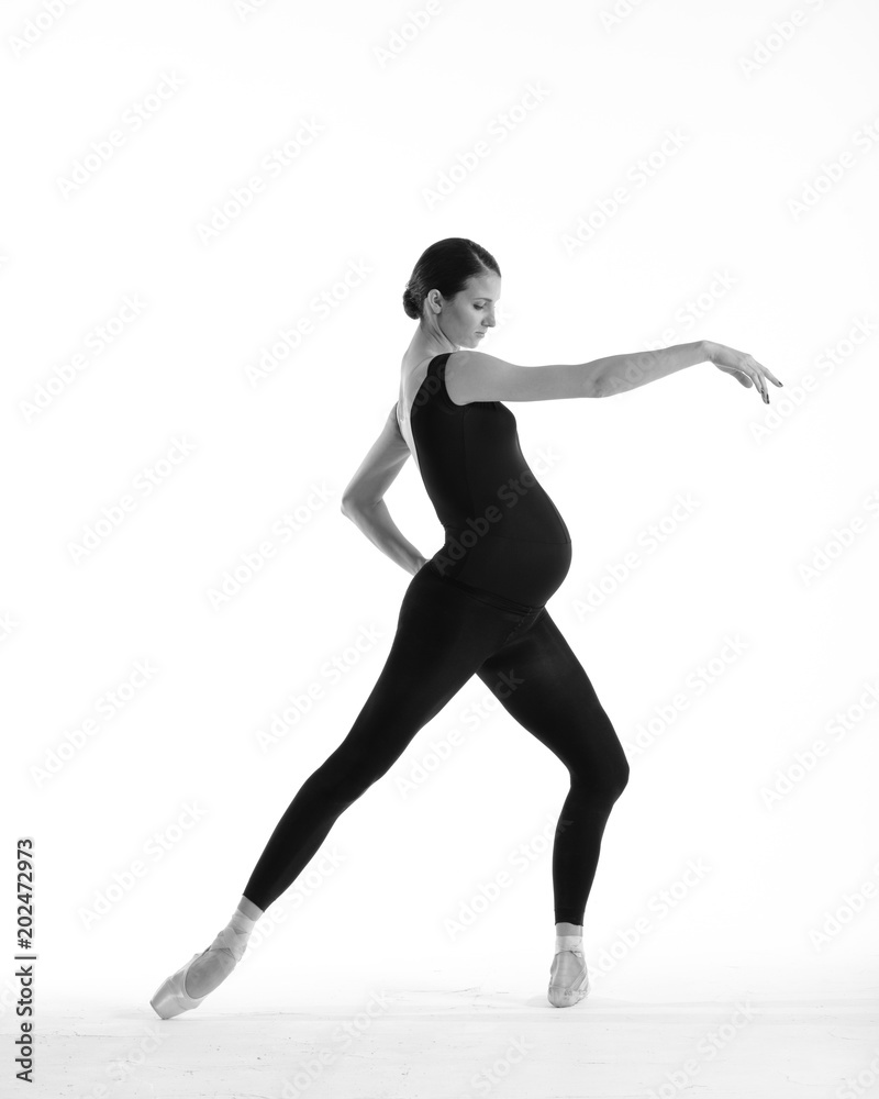 Young beautiful ballerina is posing in studio