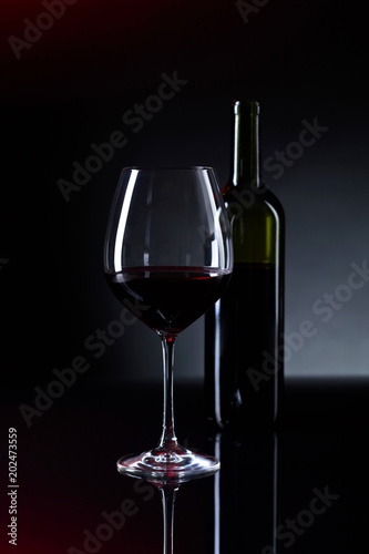 Glass and bottle of red wine.